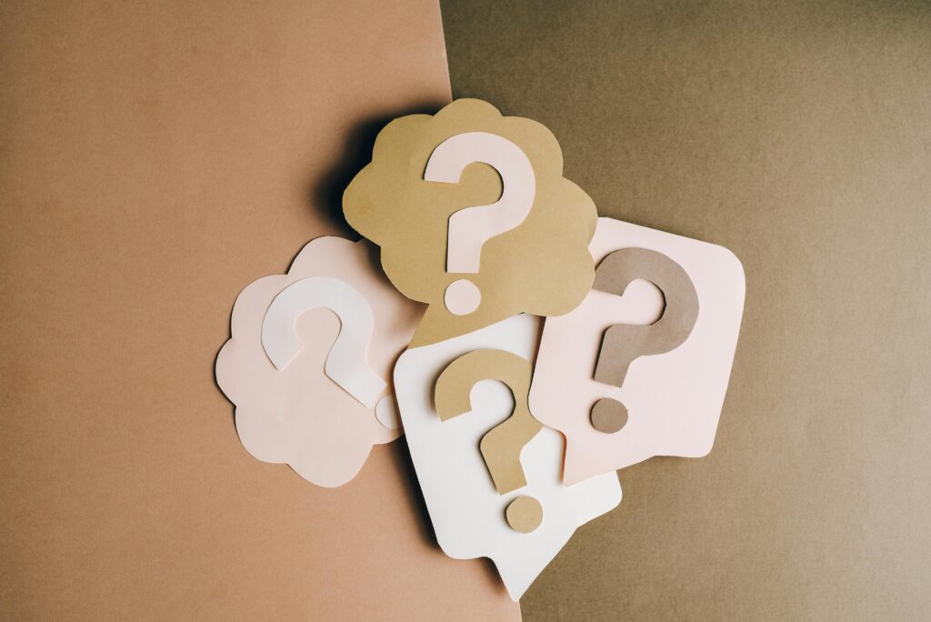 pexels-photo-5428829-5428829 Question mark cutouts in layered paper craft style on a brown backdrop, conceptual art.